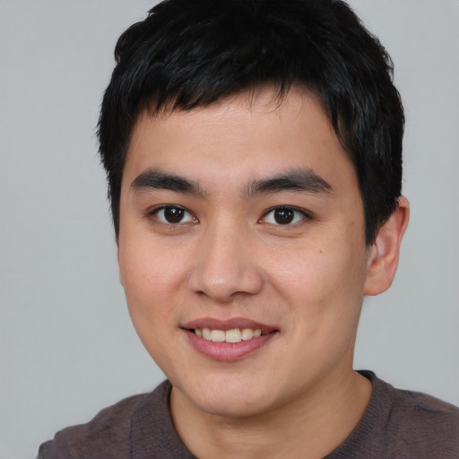 Joyful asian young-adult male with short  brown hair and brown eyes