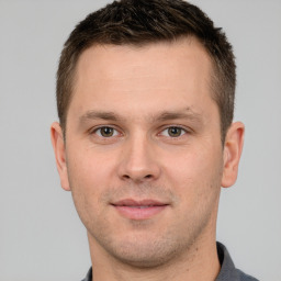 Joyful white young-adult male with short  brown hair and grey eyes