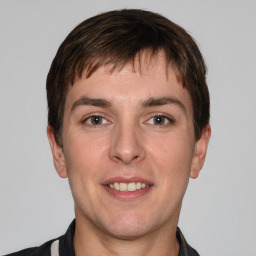 Joyful white young-adult male with short  brown hair and grey eyes