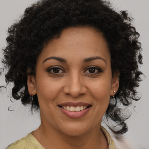 Joyful black young-adult female with medium  brown hair and brown eyes