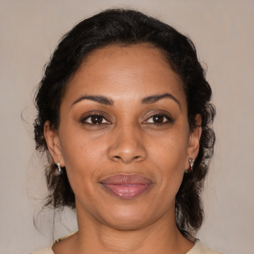 Joyful latino adult female with medium  brown hair and brown eyes