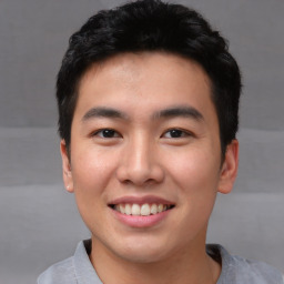 Joyful asian young-adult male with short  black hair and brown eyes