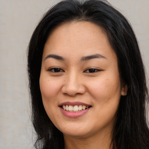 Joyful asian young-adult female with long  brown hair and brown eyes