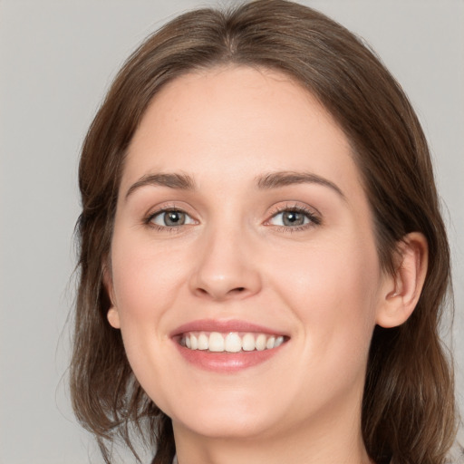 Joyful white young-adult female with medium  brown hair and grey eyes