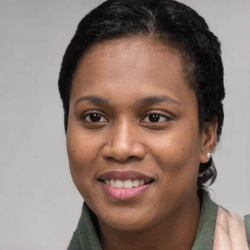 Joyful black young-adult female with short  black hair and brown eyes