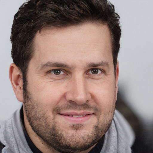 Joyful white adult male with short  brown hair and brown eyes