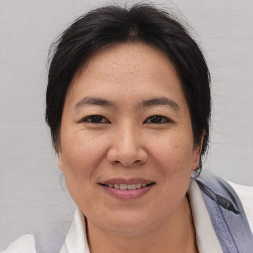 Joyful asian adult female with medium  brown hair and brown eyes
