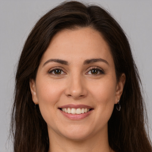 Joyful white young-adult female with long  brown hair and brown eyes