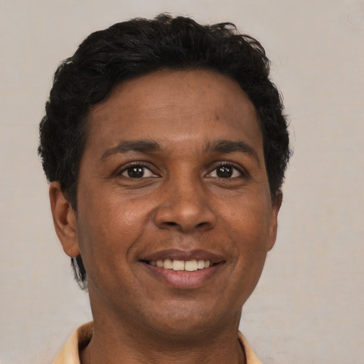 Joyful black adult male with short  brown hair and brown eyes