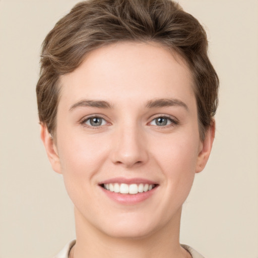 Joyful white young-adult female with short  brown hair and grey eyes