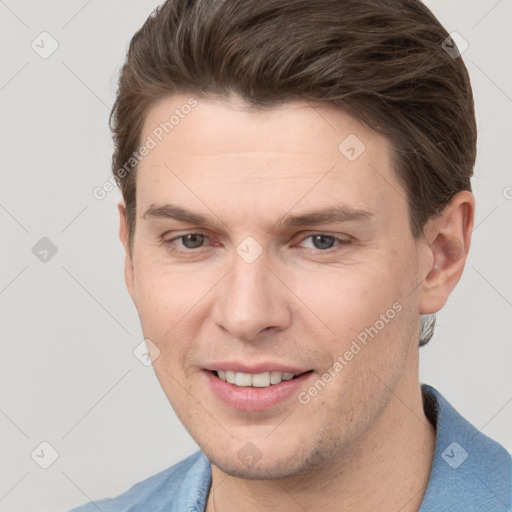 Joyful white young-adult male with short  brown hair and grey eyes