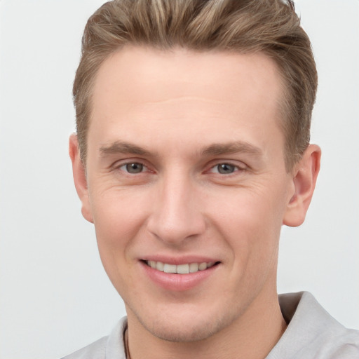 Joyful white young-adult male with short  brown hair and grey eyes