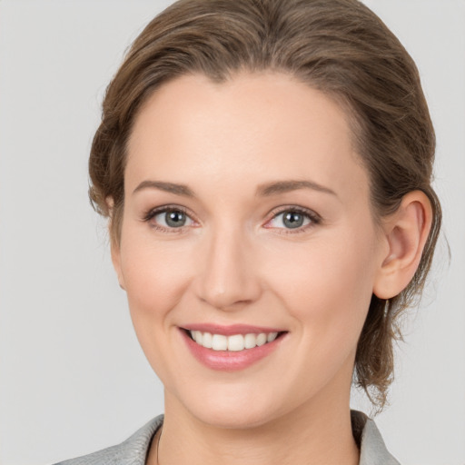 Joyful white young-adult female with medium  brown hair and grey eyes