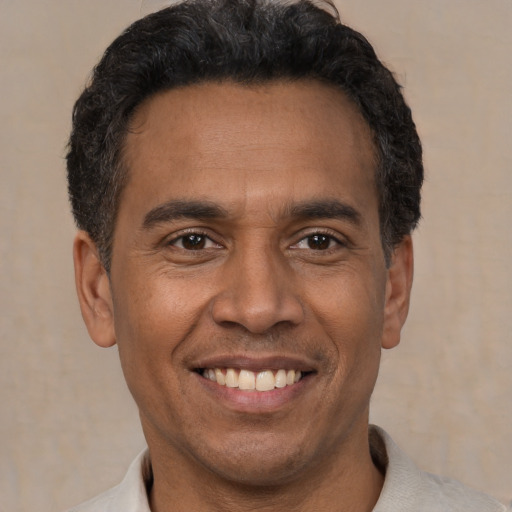 Joyful latino adult male with short  black hair and brown eyes