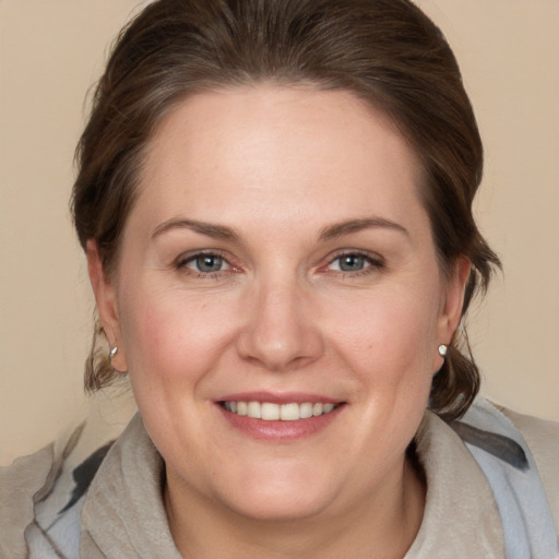 Joyful white adult female with medium  brown hair and grey eyes