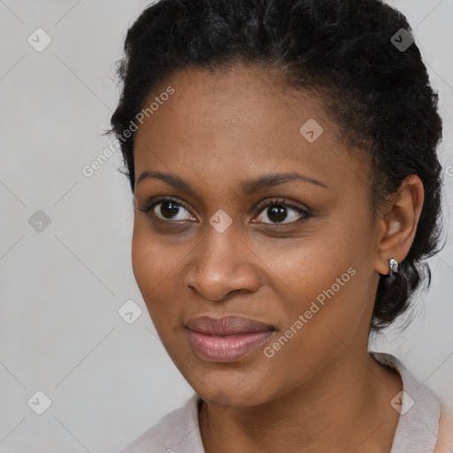 Joyful black young-adult female with short  black hair and brown eyes