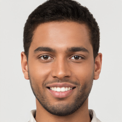 Joyful black young-adult male with short  brown hair and brown eyes