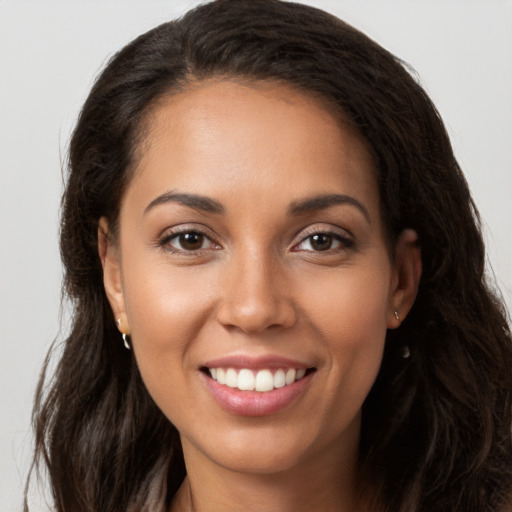 Joyful latino young-adult female with long  brown hair and brown eyes