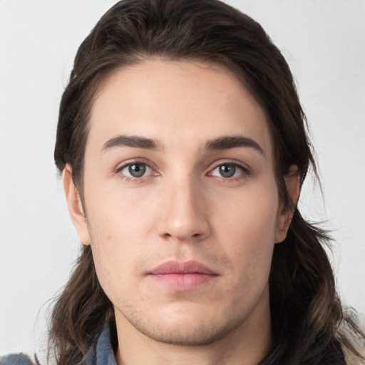 Neutral white young-adult male with long  brown hair and brown eyes