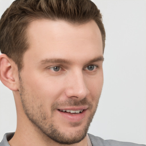 Joyful white young-adult male with short  brown hair and grey eyes