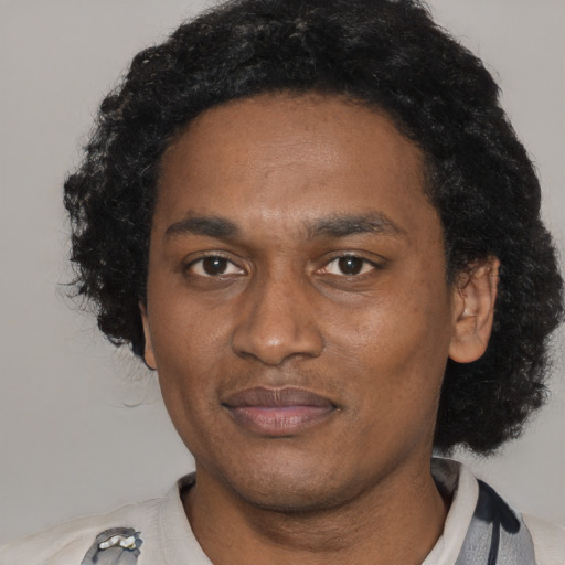 Joyful black adult male with short  black hair and brown eyes