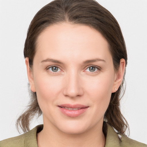 Joyful white young-adult female with medium  brown hair and grey eyes