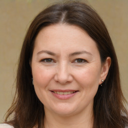 Joyful white adult female with long  brown hair and brown eyes
