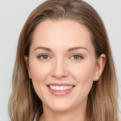 Joyful white young-adult female with long  brown hair and grey eyes