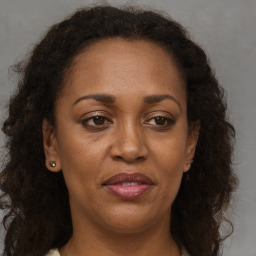 Joyful black adult female with long  brown hair and brown eyes