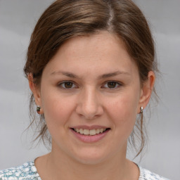 Joyful white young-adult female with medium  brown hair and grey eyes