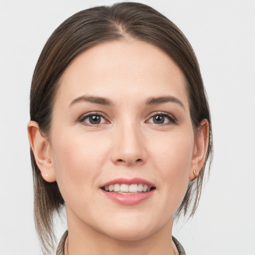 Joyful white young-adult female with medium  brown hair and grey eyes