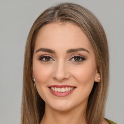 Joyful white young-adult female with long  brown hair and green eyes