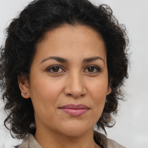 Joyful latino adult female with long  brown hair and brown eyes