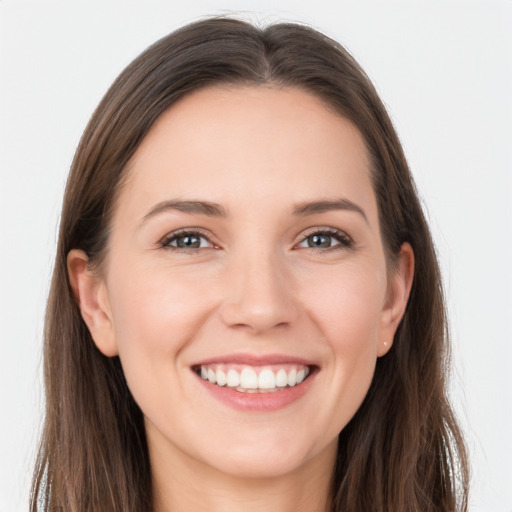 Joyful white young-adult female with long  brown hair and grey eyes