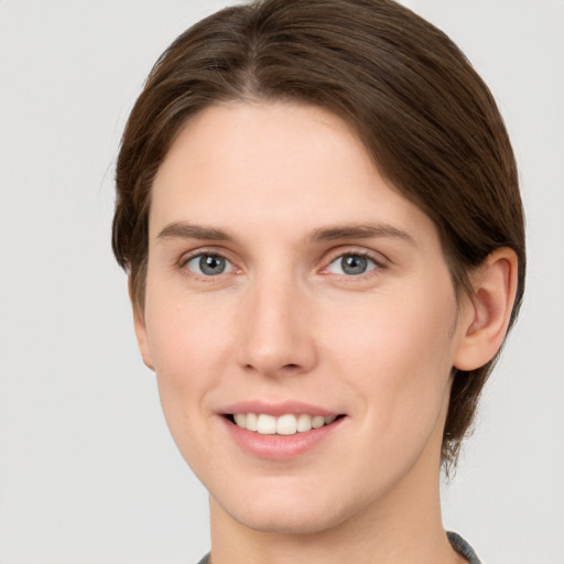 Joyful white young-adult female with short  brown hair and grey eyes