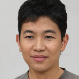 Joyful asian young-adult male with short  black hair and brown eyes