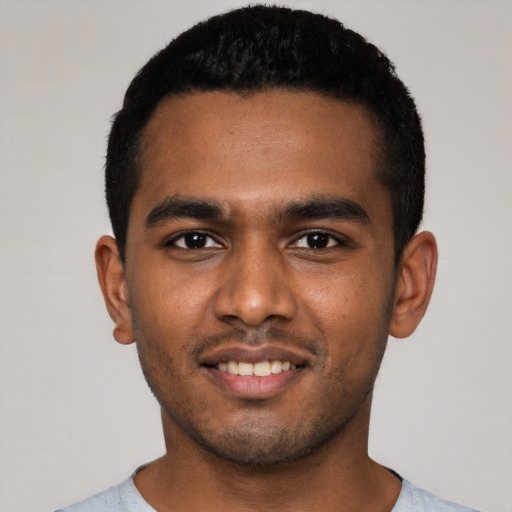 Joyful black young-adult male with short  black hair and brown eyes