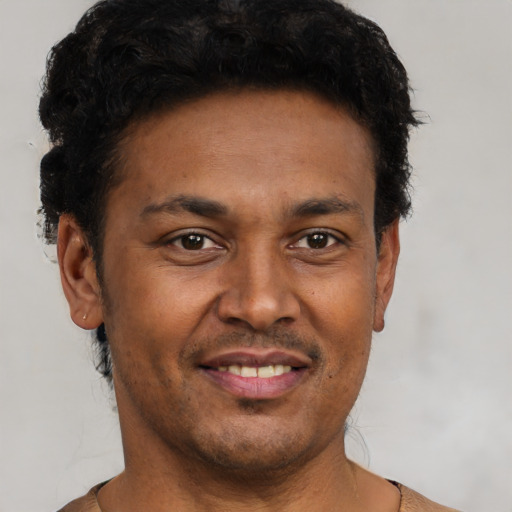 Joyful black young-adult male with short  black hair and brown eyes