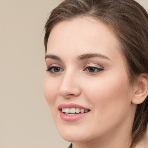 Joyful white young-adult female with long  brown hair and grey eyes