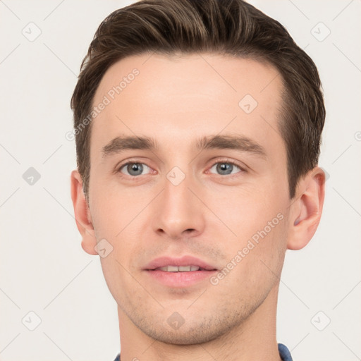 Joyful white young-adult male with short  brown hair and grey eyes