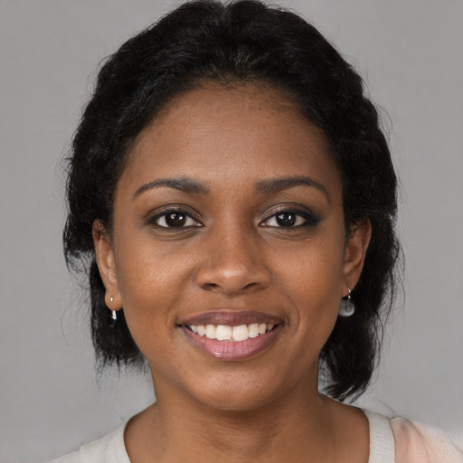 Joyful black young-adult female with medium  black hair and brown eyes