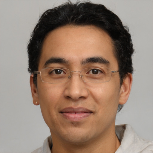 Joyful latino adult male with short  brown hair and brown eyes
