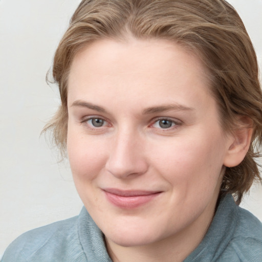 Joyful white young-adult female with medium  brown hair and blue eyes