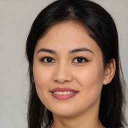 Joyful latino young-adult female with long  brown hair and brown eyes