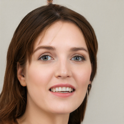 Joyful white young-adult female with long  brown hair and green eyes