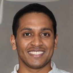 Joyful latino young-adult male with short  brown hair and brown eyes