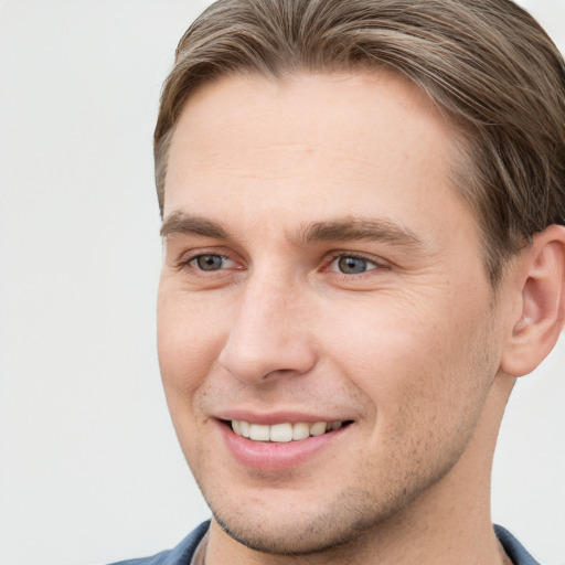 Joyful white young-adult male with short  brown hair and grey eyes