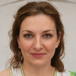 Joyful white adult female with medium  brown hair and grey eyes