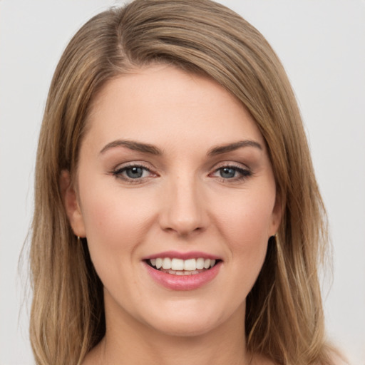 Joyful white young-adult female with medium  brown hair and green eyes