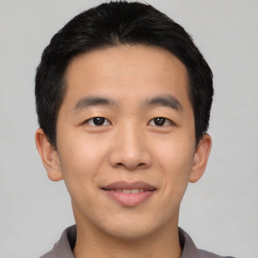 Joyful asian young-adult male with short  black hair and brown eyes